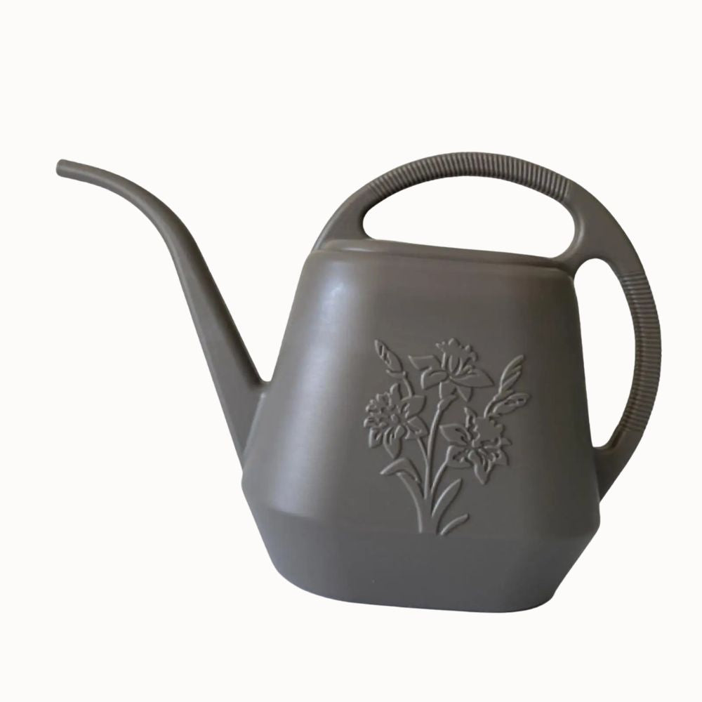 Arrosoir en plastique gris avec un long bec et un motif floral sur le corps