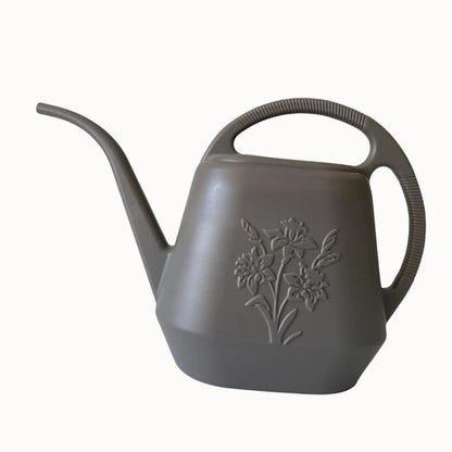 Arrosoir en plastique gris avec un long bec et un motif floral sur le corps