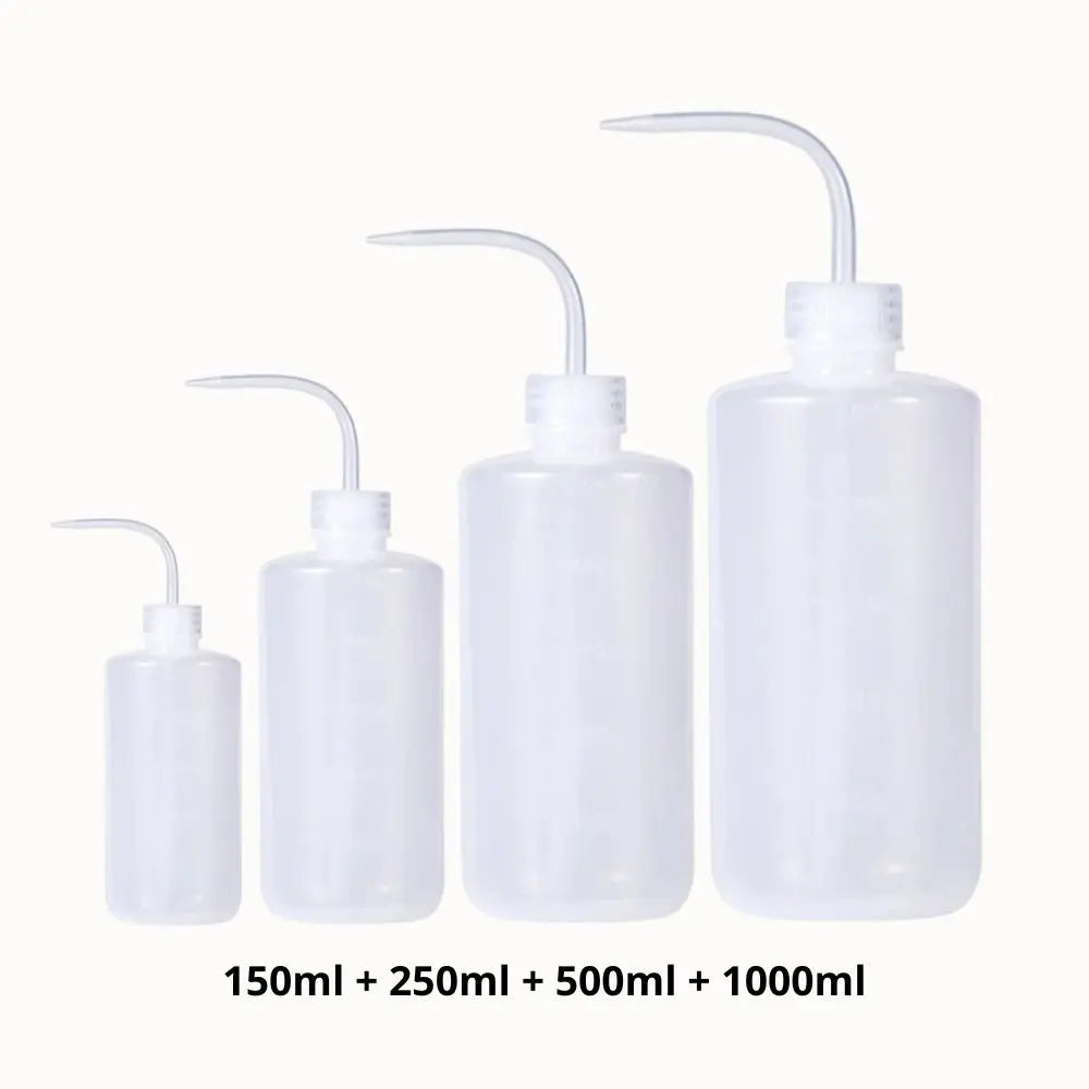 Quatre bouteilles transparentes de différentes tailles avec un bec verseur, posées sur un fond clair