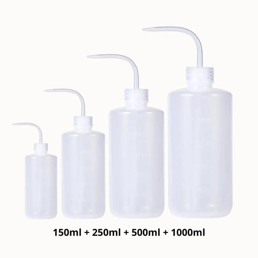 Quatre bouteilles transparentes de différentes tailles avec un bec verseur, posées sur un fond clair