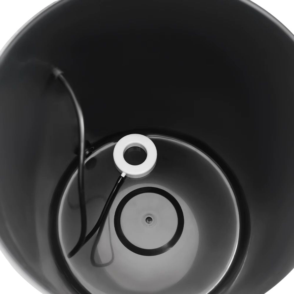 Intérieur d'un bac noir avec un tuyau et un anneau blanc au centre, surface lisse et circulaire