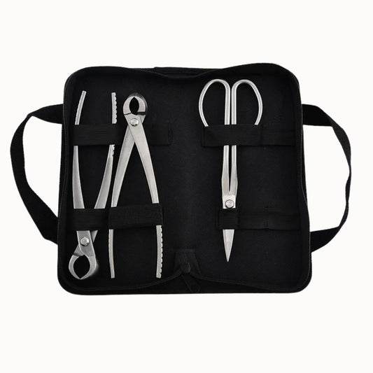 Trois outils de coupe en acier inoxydable présentés dans une trousse noire avec des compartiments