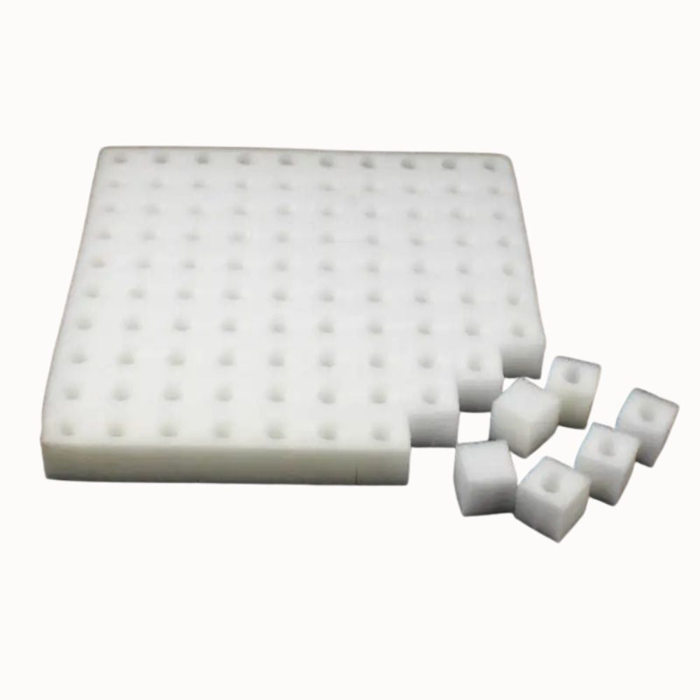 Éponge blanche avec des alvéoles, forme carrée et cubes découpés sur un fond neutre