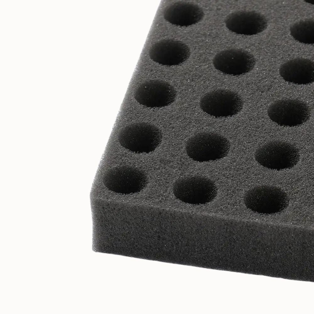 Éponge noire avec alvéoles circulaires, texture douce et surface uniforme, idéale pour le semis