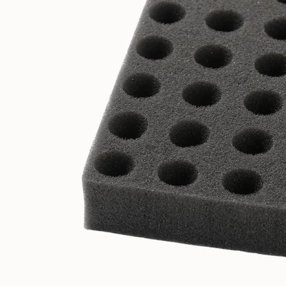 Éponge noire avec alvéoles circulaires, texture douce et surface uniforme, idéale pour le semis