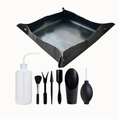 Tapis noir étanche avec accessoires de soin, incluant un flacon, brosses et outils de jardinage