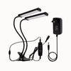 Deux lampes LED noires avec bras flexibles et un adaptateur, sur fond blanc