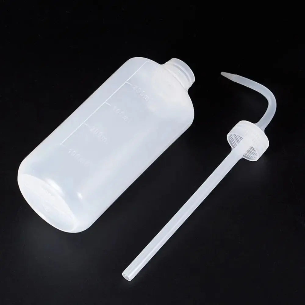 Flacon transparent avec bec courbé et capuchon, sur fond noir, montrant une forme allongée et lisse