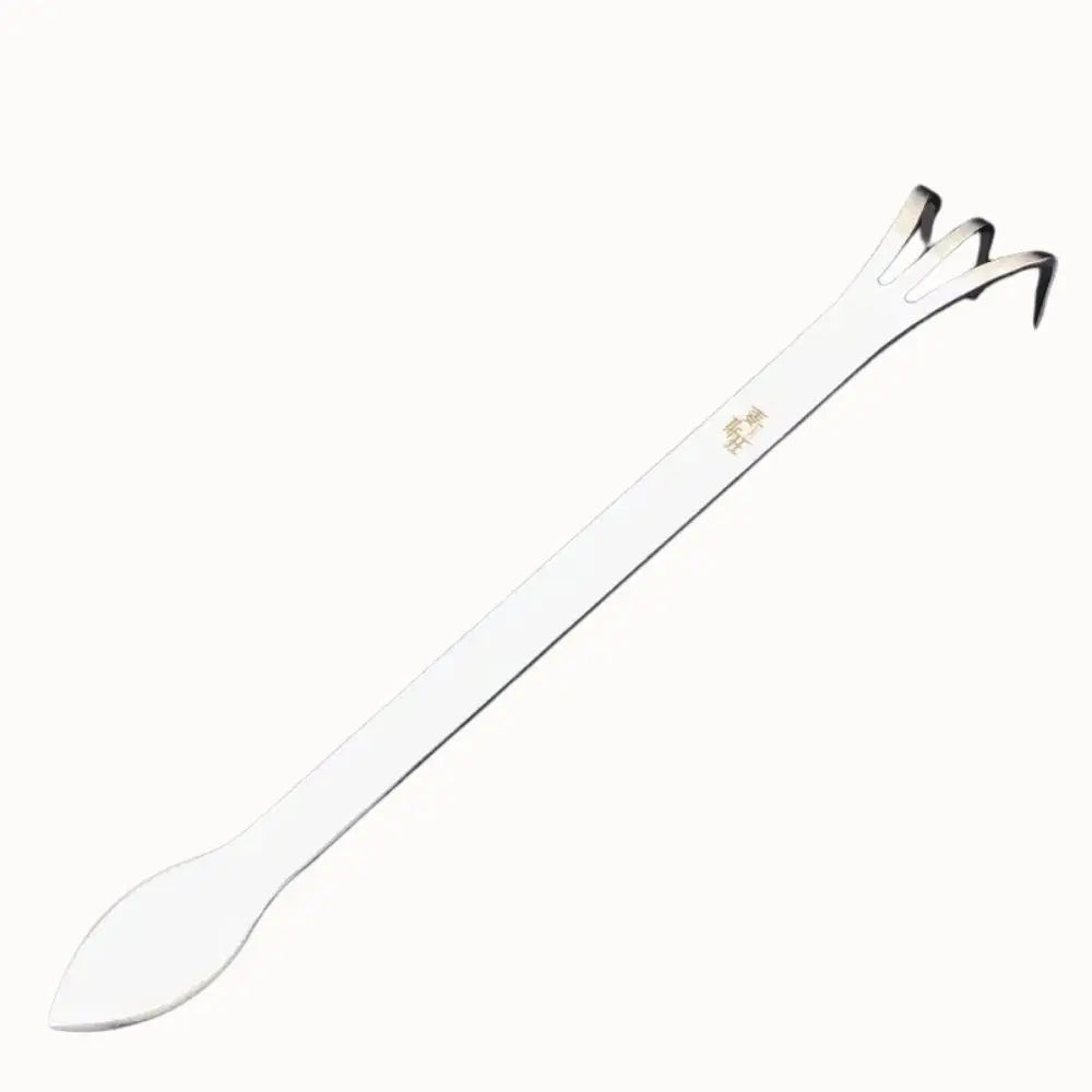 Outil de pressage en plastique blanc avec une extrémité en forme de spatule et des bords fins