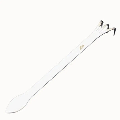 Outil de pressage en plastique blanc avec une extrémité en forme de spatule et des bords fins