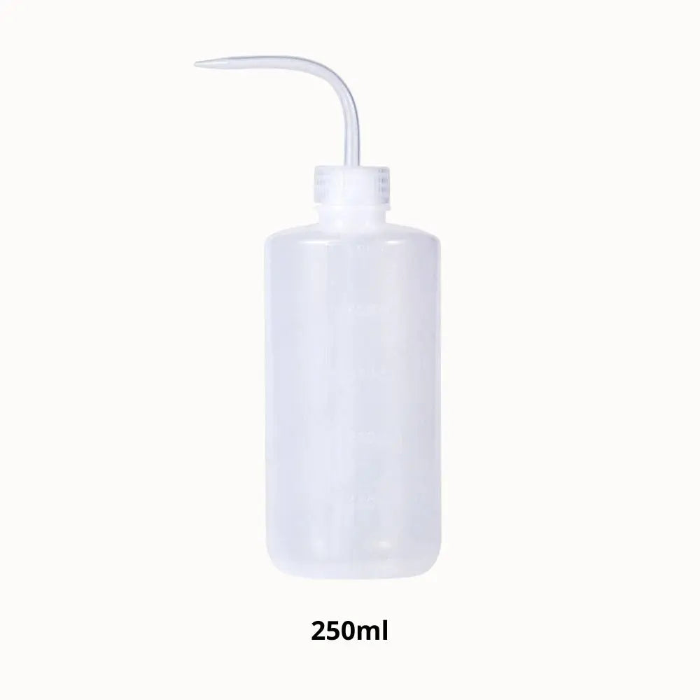 Flacon transparent de forme cylindrique avec un long bec verseur et un bouchon blanc