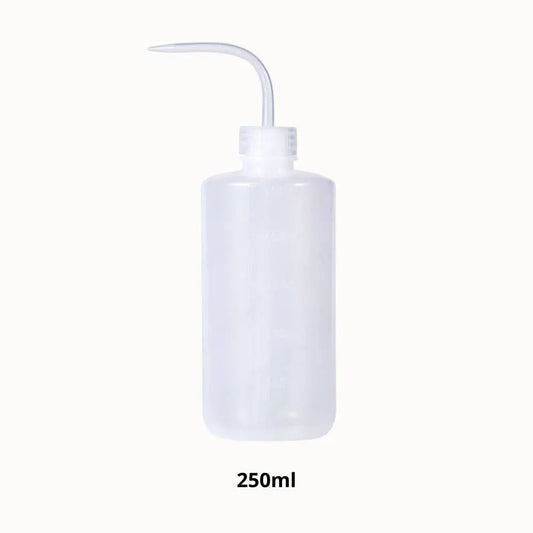 Flacon transparent de forme cylindrique avec un long bec verseur et un bouchon blanc
