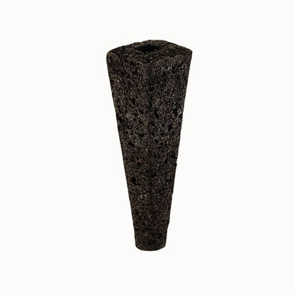Éponge biochar noire en forme conique, texture poreuse et surface rugueuse, sur fond clair