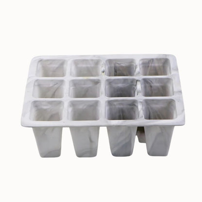 Bac en silicone blanc marbré avec douze cellules pour semis et drainage visible