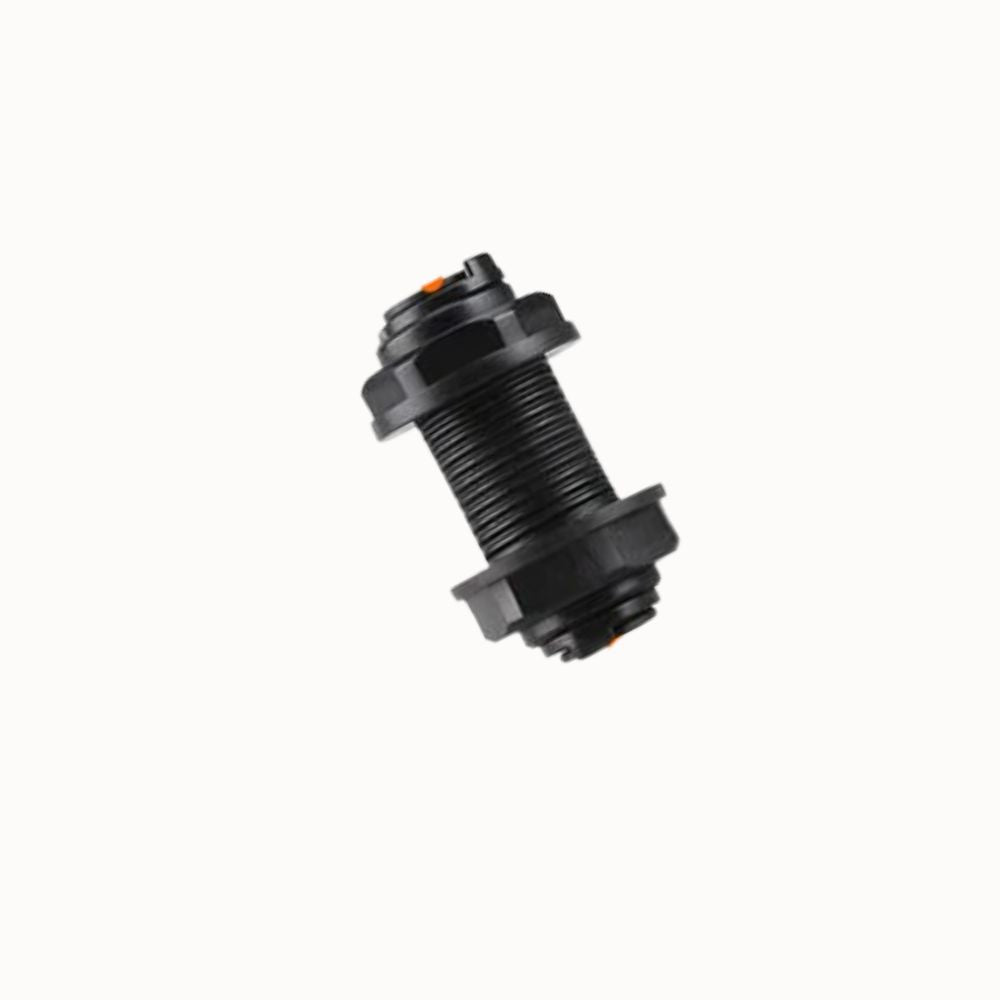 Raccord traversant de paroi en plastique noir avec filetage et joint orange visible sur l'image