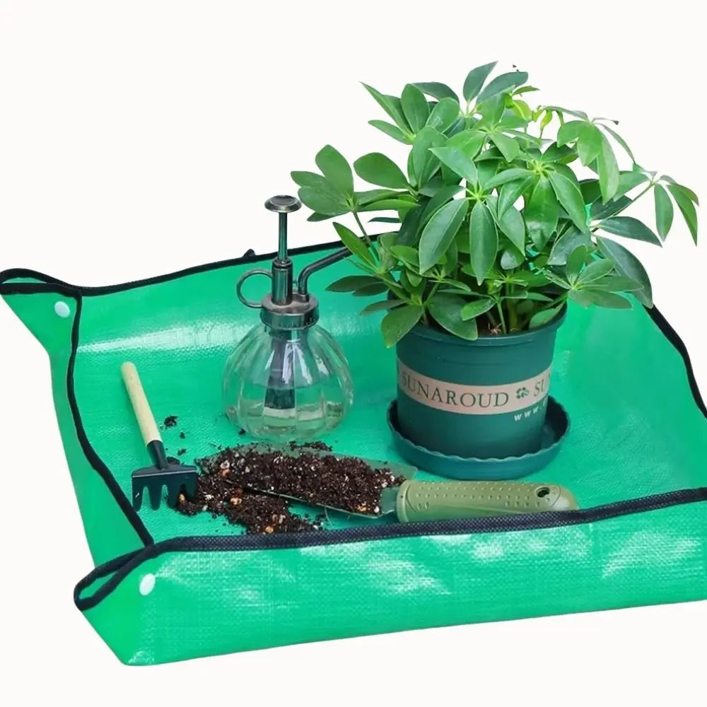 Tapis de rempotage vert avec un pot de plante, un arrosoir et une petite pelle en métal