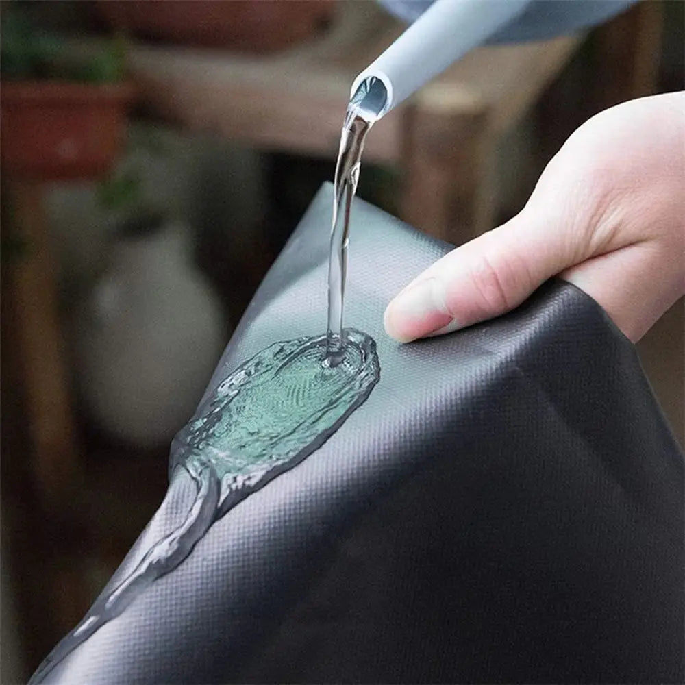Surface en PVC noir avec une main versant de l'eau, texture lisse et brillante, décor minimaliste