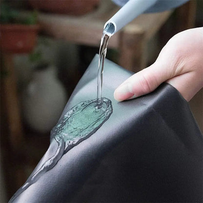 Surface en PVC noir avec une main versant de l'eau, texture lisse et brillante, décor minimaliste