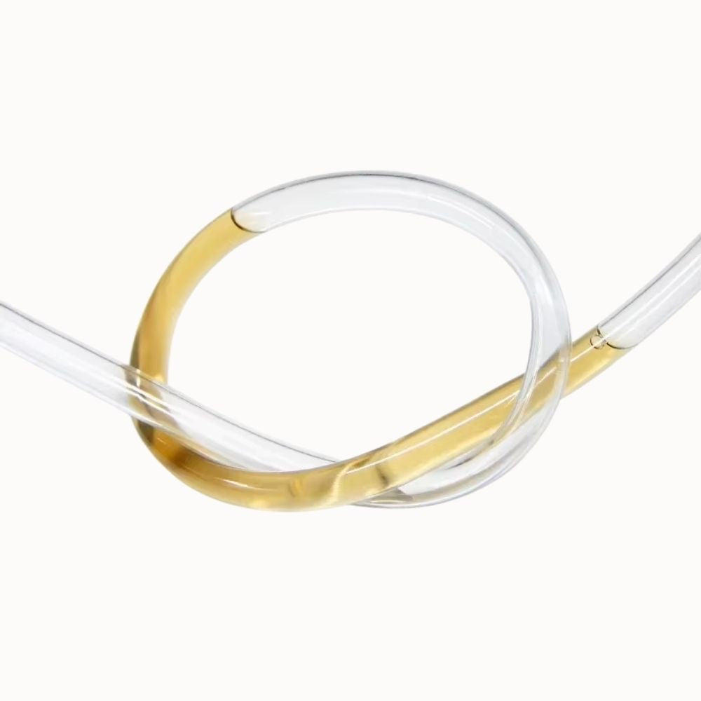 Tube PVC transparent de 22 mm avec une courbure et une teinte dorée sur une surface claire
