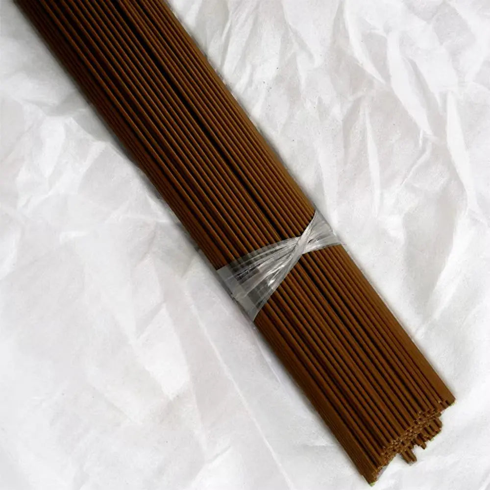 Tige pliable en métal brun regroupée avec un film transparent sur un fond blanc texturé